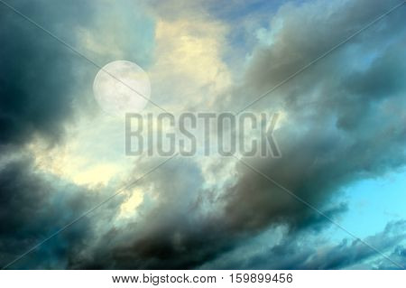Moon clouds night skies is a vibrant surreal fantasy like cloudscape with the ethereal heavenly full moon rising among the vibrant wispy colorful cloudscape.
