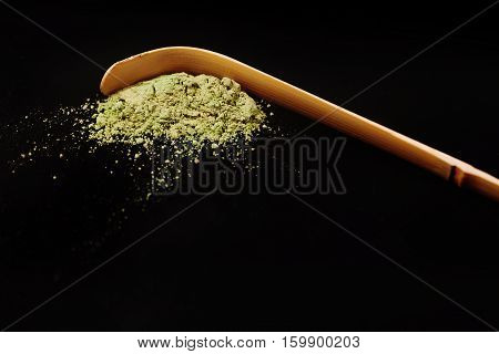 Special bamboo spoon for green powdered matha tea isolated on black background.