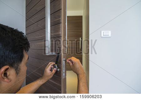 locksmith try to fix wood door with screwdriver - can use to display or montage on product