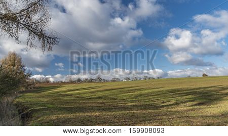 Green Field With Blue Sky And White Clouds In Autumn Time