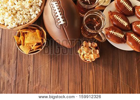 Table full of tasty snacks and beer prepared for watching rugby on TV
