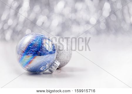 Silver and Blue Christmas ornaments balls on glitter bokeh background with space for text. Xmas and Happy New Year theme