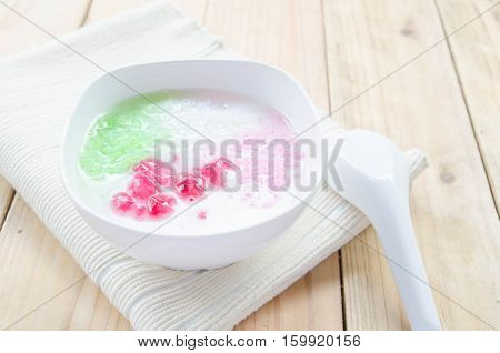 Tub Tim Krob ,Stuffed Water Chestnut in Syrup and Coconut Milk on wood table thailand dessert.