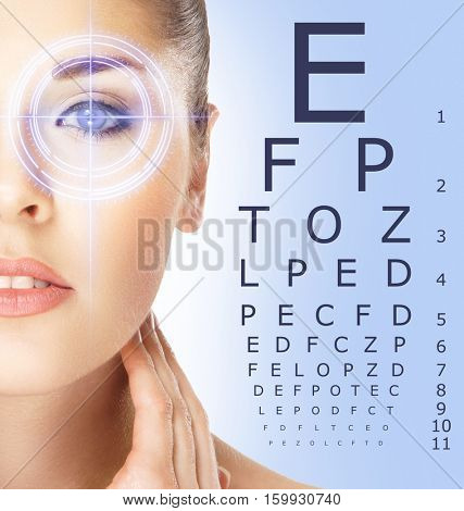 Beautiful woman with laser hologram and test vision table over cyan background.