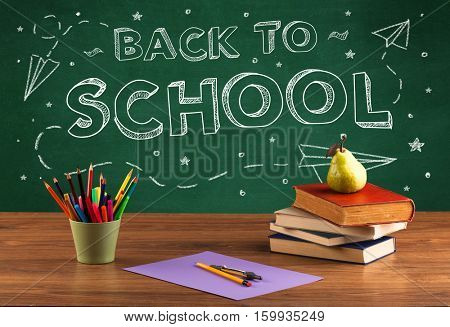 Back to school concepty with writing on blackboard and desk, apple, books, items