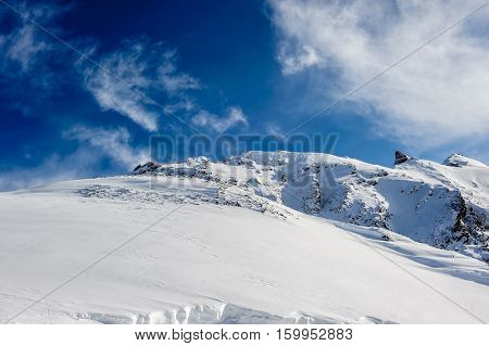 Alpine winter mountain landscape. French Alps covered with snow in sunny day. Val-d'Isere, France