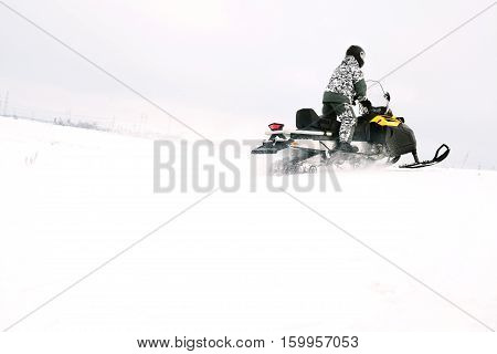 Man on snowmobile. Recreation concept on nature in winter holidays. Winter sports.