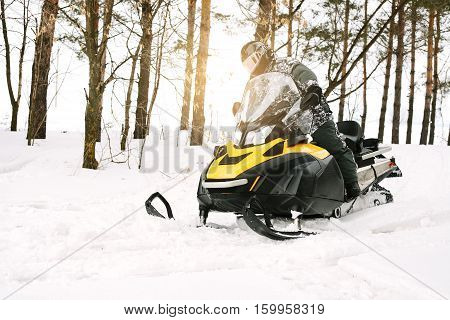 The sportsman on a snowmobile. Recreation concept on nature in winter and New Year holidays. Winter sports.