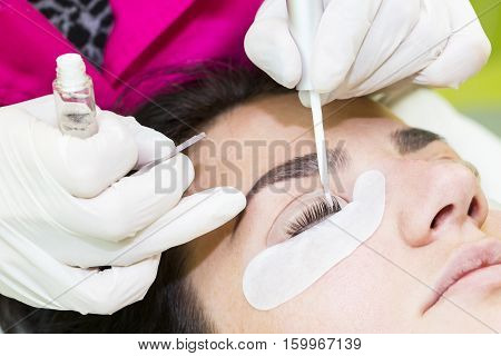 Woman on the procedure for eyelash extensions, eyelashes lamination