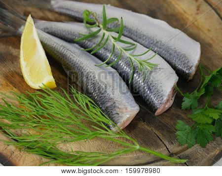 three herrings with lemon on a chopping board