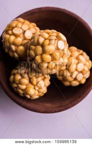 Putnala / futana  / Dalia / Roasted Chickpeas sweet Laddu made up of jaggery or gud or gur in hindi, selective focus