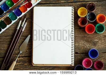 Art of Painting. Painting set: paper brushes paints crayons watercolor acrylic paint on a wooden background