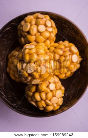Putnala / futana  / Dalia / Roasted Chickpeas sweet Laddu made up of jaggery or gud or gur in hindi, selective focus