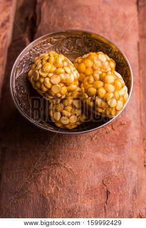 Putnala / Dalia / Roasted Chickpeas sweet Laddu made up of jaggery or gud or gur in hindi, selective focus