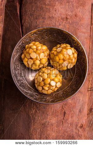 Putnala / Dalia / Roasted Chickpeas sweet Laddu made up of jaggery or gud or gur in hindi, selective focus