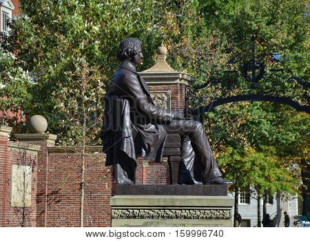 CAMBRIDGE USA - OCTOBER 20 2014: Statue of Charles Sumner in front of Harvard University entrance. Harvard is the most prestigious and oldest university in United States