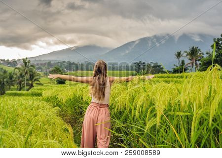 Young Woman Traveler On Beautiful Jatiluwih Rice Terraces Against The Background Of Famous Volcanoes
