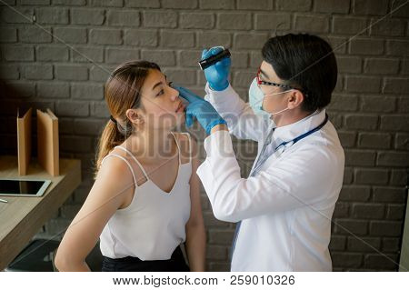 Doctor Wear White Coat Shines A Flashlight To The Patient's Eyes At The Clinic. Concept Of Healthcar