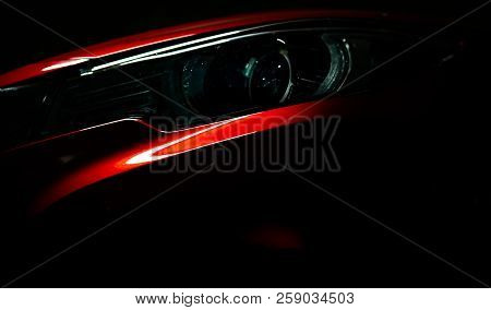 Closeup Headlight Of Shiny Red Luxury Suv Compact Car. Elegant Electric Car Technology And Business 