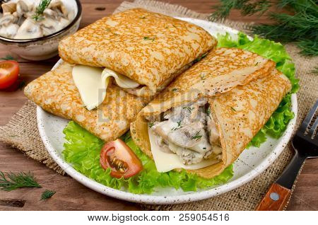 Pancakes Stuffed With Mushrooms And Cheese With Cream Sauce. Traditional Russian Food