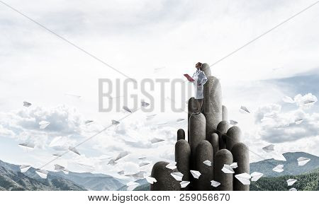 Young Female Doctor With Folder In Hands Satnding On Stone Column