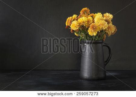 Autumn Dark Still Life. Fall With Yellow Chrysanthemum Flowers In Clayware Vase On Black.