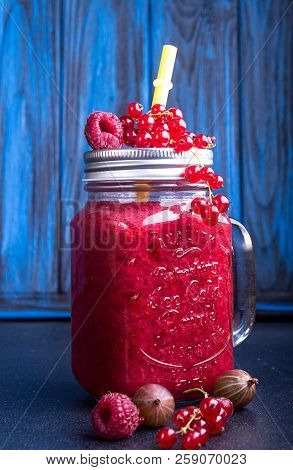 Summer Smoothies Of Raspberries, Red Currant, Goosberries In Glasse On Blue Background.