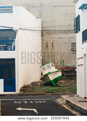 Lanzarote, Spain - December 12, 2017: Abandoned Boat Next To Residential Building On December 12, 20