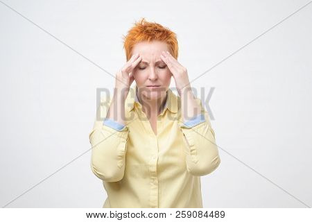 Exhausted Mature Woman Touching Her Head With Eyes Closed. Suffering From Unbearable Headache.