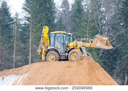 Wheel Loader Excavator With Backhoe Unloading Sand At Eathmoving Works In Construction Site Quarry