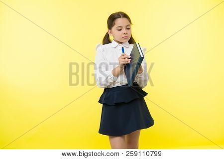Child School Uniform Smart Kid Hold Textbook. Girl Happy Face Carry Textbook Yellow Background. Chil