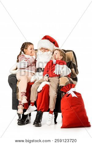 Kids Whispering To Santa While Thay Sitting In Armchair Together Isolated On White