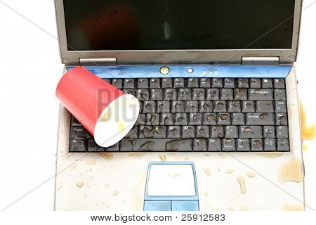 un ordenador portátil con el líquido derramado en el teclado aislado en blanco