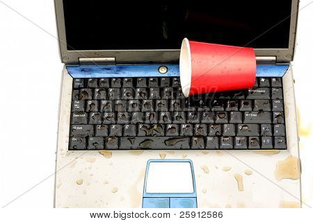 un ordenador portátil con el líquido derramado en el teclado aislado en blanco
