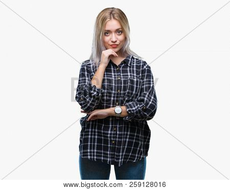 Young blonde woman over isolated background with hand on chin thinking about question, pensive expression. Smiling with thoughtful face. Doubt concept.