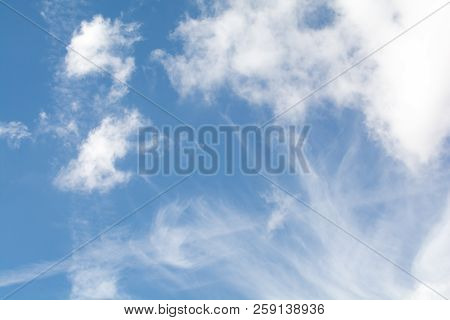 Whispy White Clouds Over A Blue Sky Background
