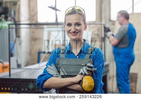 Workers in a metal workshop, man and woman