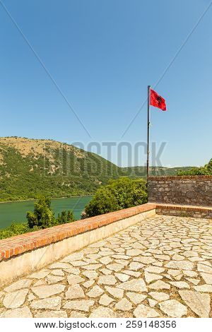 View Of The Albanian Flag Located On A Hill In The Butrint National Park, South Albania