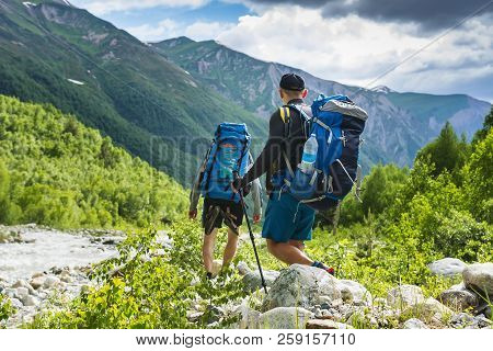 Tourists In Mountain Trek. Two Friends In Mountains. Hiking On Hills And Mounts. Hikers Walks On Roc