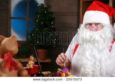 Babbo Natale detiene sue bretelle rosse come si prende una pausa dal fare i regali di Natale per i bambini