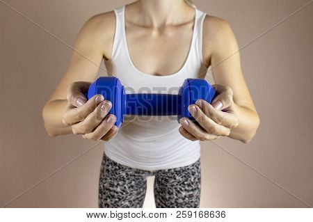 Cropped Woman In White Shirt With Dambbell In Her Hands Clase Up. Slimming Diet And Fitness Concept.