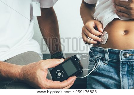 Cropped View Of The Hands Of A Diabetic Child Applying An Insulin Pump Dressing In His Abdomen With 