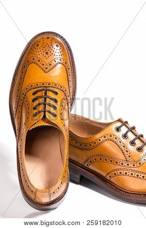 Partial View Of Pair Of Luxury Male Full Brogued Tan Oxford Shoes. Isolated Over White Background.ve