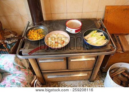 Many Pots On The Wood Burning Stove In The Kitchen Of An Old House