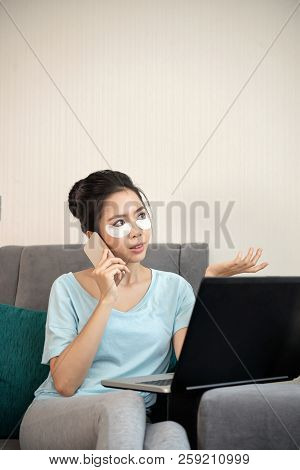 Portrait Of Young Asian Woman Wearing Hygro Gel Under Eye Patches When Talking On Phone