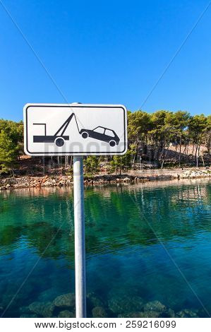 Car Towing Sign By The Sea. Street Sign Of A Car Being Removed In White Color. No Stopping Clearway 