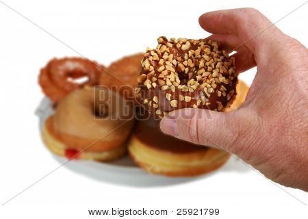 seçici odak bir fıstık ve çikolata tutan insan elde beyaz izole donut sırlı