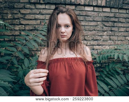 Beautiful woman standing outdoor at rustick brick wall