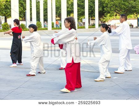 Sanya, China : 11 Nov 2017: Women And Men In The Street In The Park Gymnastics Wushu.