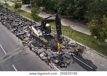 Excavator Breaking Concrete Road Surface With Hydrohammer Drill At Repairing Roadwork. Overhaul Of T